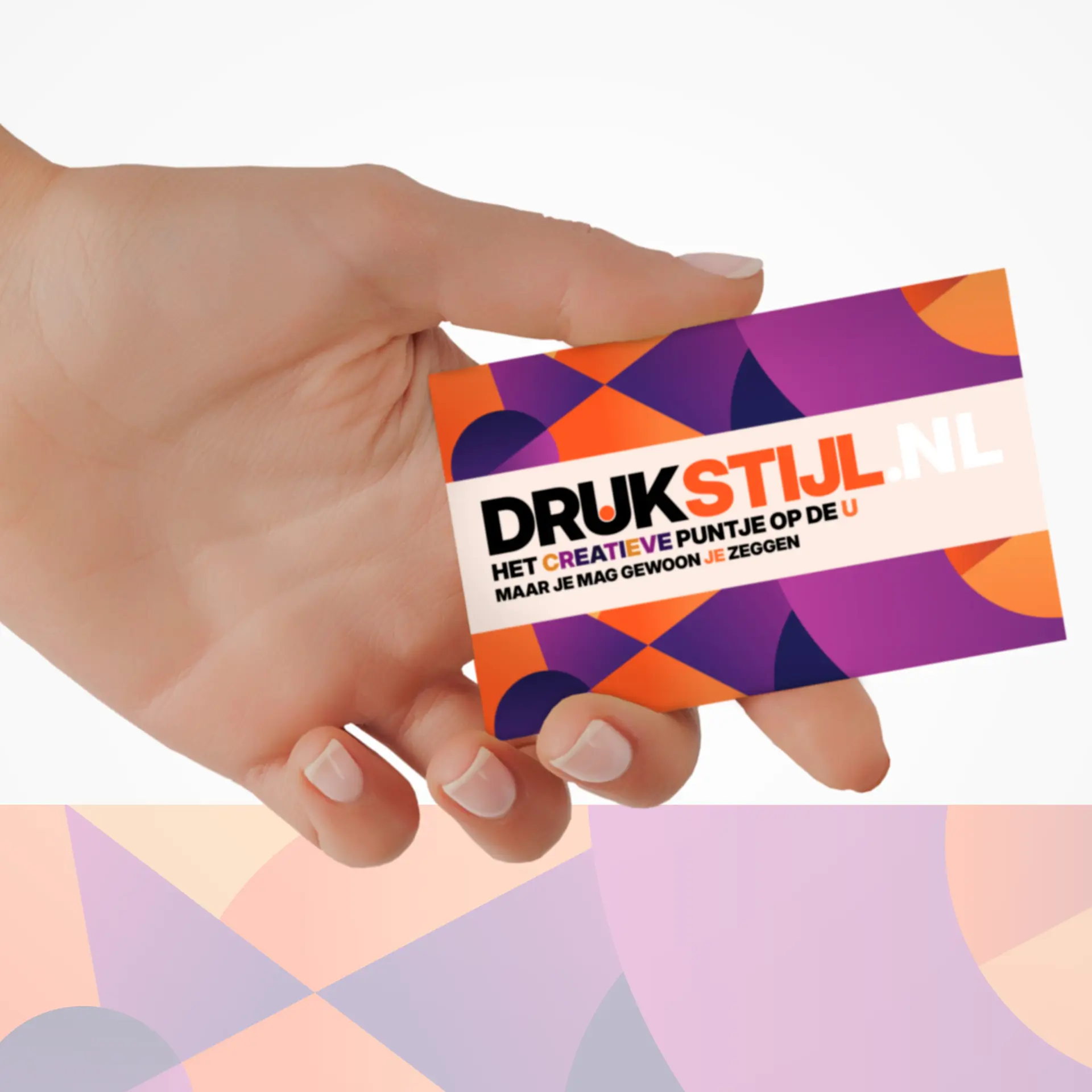 Hand met een DRUKSTIJL-kaartje op paars-oranje achtergrond