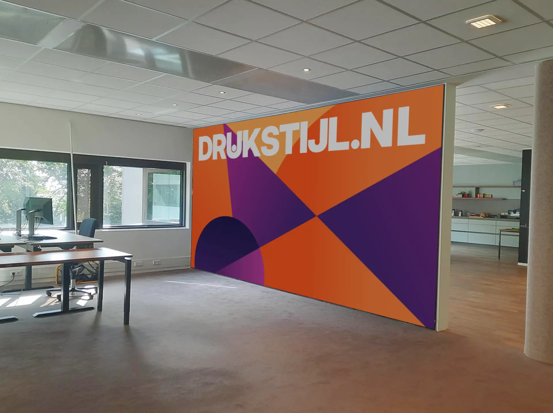 Grote wanddecoratie met DRUKSTIJL.NL opdruk in een kantoorruimte
