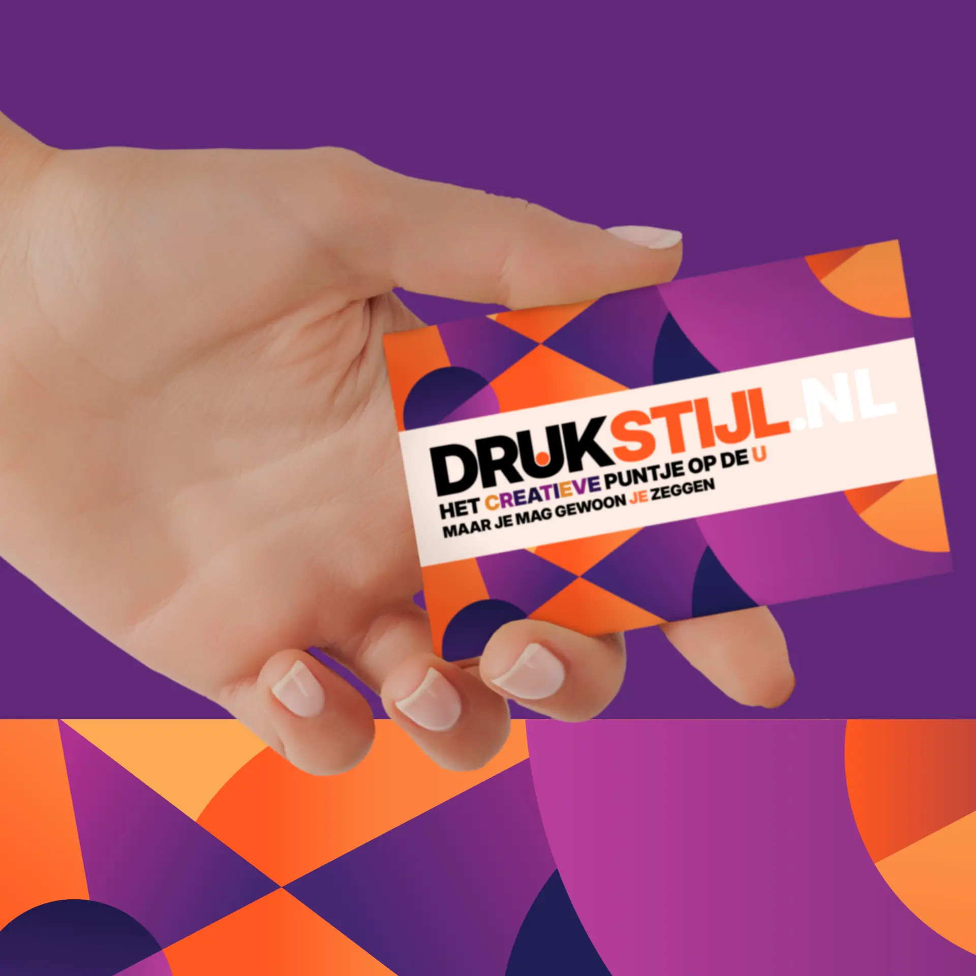 Hand met een DRUKSTIJL-kaartje op paars-oranje achtergrond