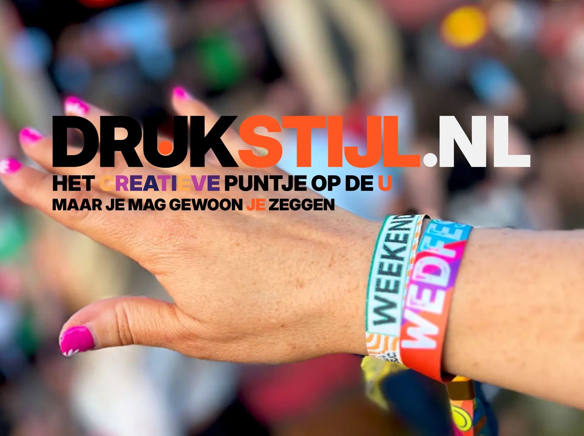 Hand met meerdere gekleurde festival polsbandjes om de pols
